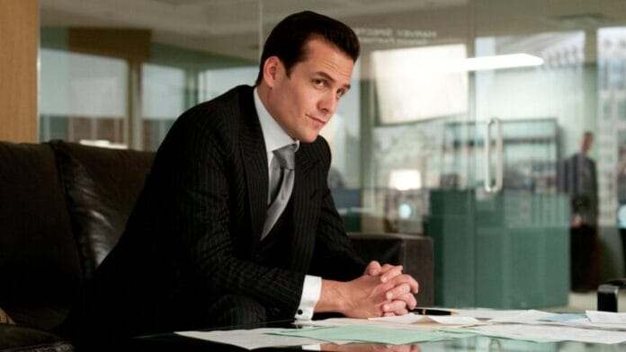 Harvey Specter istuu pöydän äärellä. Pukumiehet palaavat.