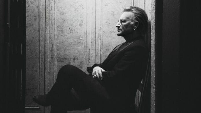 Bono istumassa tuolilla. Bono: Stories of Surrender saapuu!